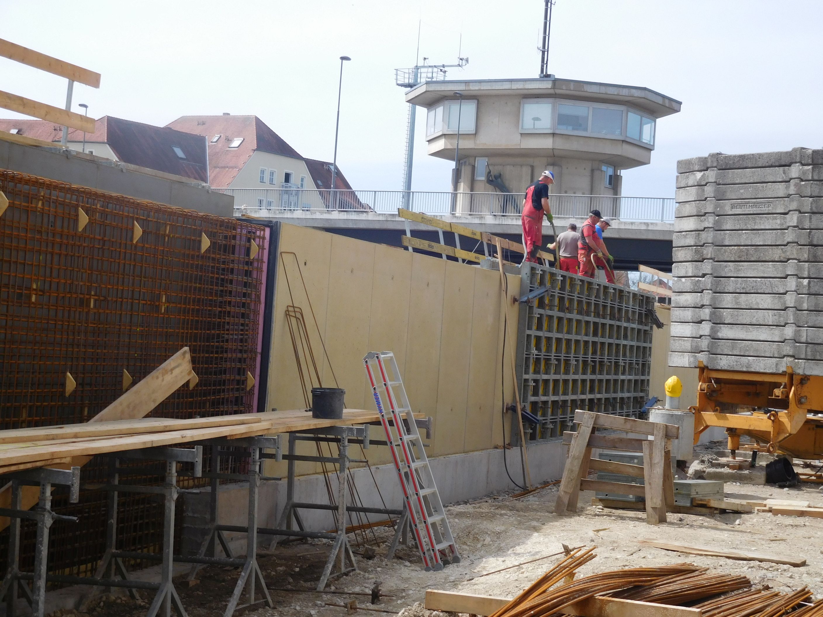 Schalung für die Hochwasserschutzmauer, Arbeiter auf der Mauer, im Hintergrund die Kanalbrücke