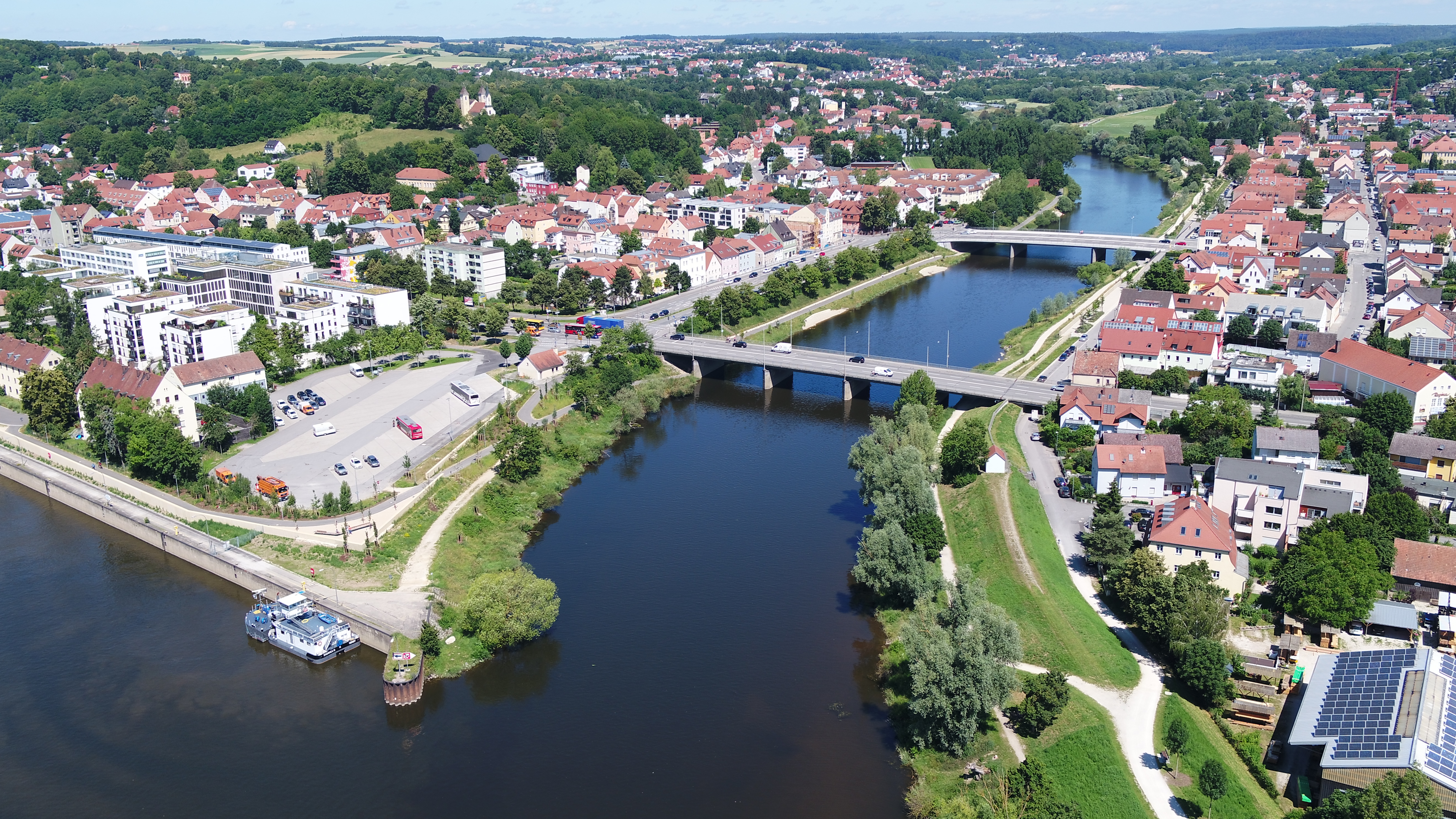 Luftbild von der Einmündung des Flusses Regen in die Donau, hintereinander über den Regen zwei Brücken, auf beiden Uferseiten die neuen Hochwasserschutzmaßnahmen mit Bepflanzung und Bebauung 