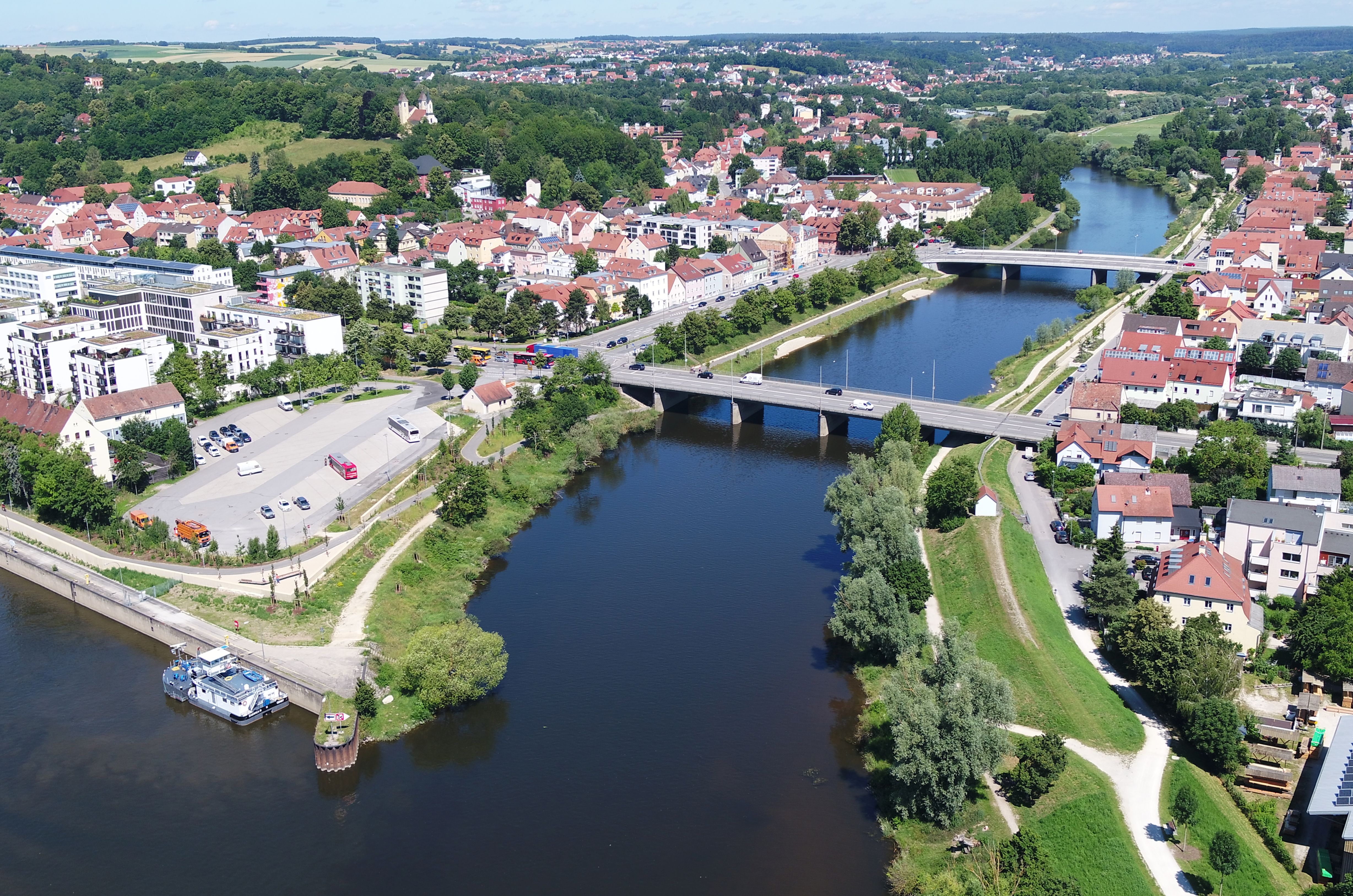 Luftbild von der Einmündung des Flusses Regen in die Donau, hintereinander über den Regen zwei Brücken, auf beiden Uferseiten die neuen Hochwasserschutzmaßnahmen mit Bepflanzung und Bebauung 