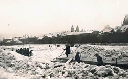 aufgetürmte Eisschollen im Vordergrund; im Hintergrund der Dom und die Altstadt