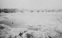 aufgetürmte Eisschollen; im Hintergrund die Steinerne Brücke