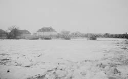 aufgetürmte Eisschollen mit der Eisernen Brücke im Hintergrund