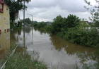 Überflutete Straße, links Häuser die im Wasser stehen