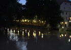 Blick auf den beleuchteten Spitalgarten bei Nacht mit Donau im Vordergrund