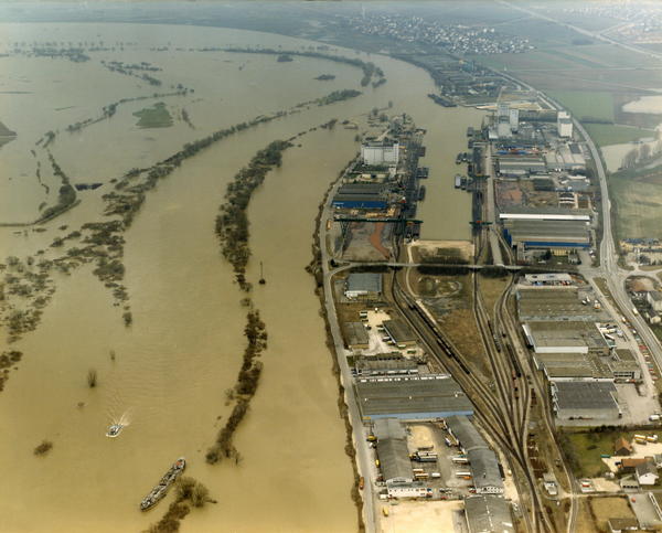 Ein Luftbild auf den Osthafen und links davon ist das restliche Land vollständig überflutet von braunem Wasser.