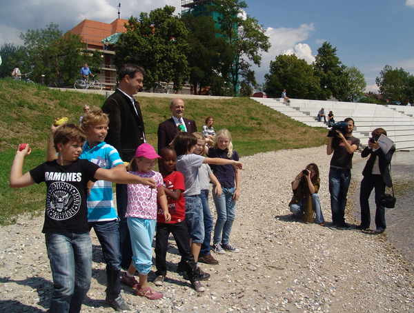 Umweltminister Söder, Oberbürgermeister Schaidinger und Kinder werfen Steine in die Donau