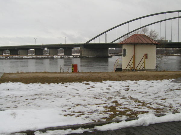 Donau im Winter und Schnee am Ufer. Rechts die Osttangentenbrücke von Schwabelweis und im linken Vordergrund das alte Pegelhaus