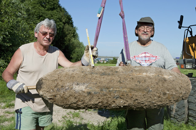 Bombenfund im Westhafenbereich Zwei Bauarbeiter mit der großen Bombe im Vordergrund, die an einem Seilzug hängt!